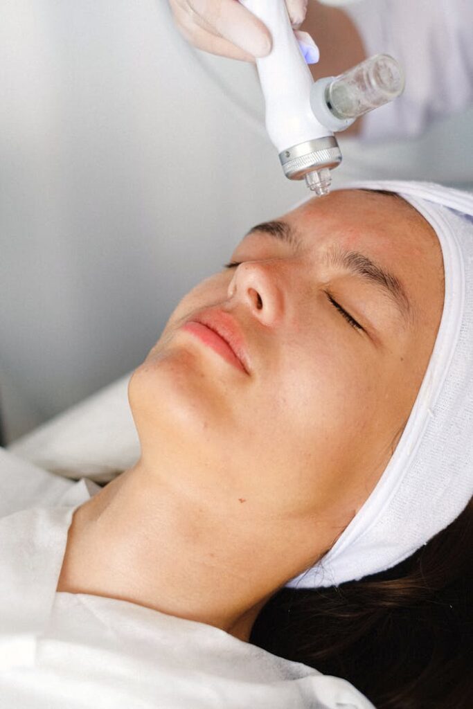 pexels photo 5069612 High angle of crop professional cosmetician doing face skin care therapy with laser tool
