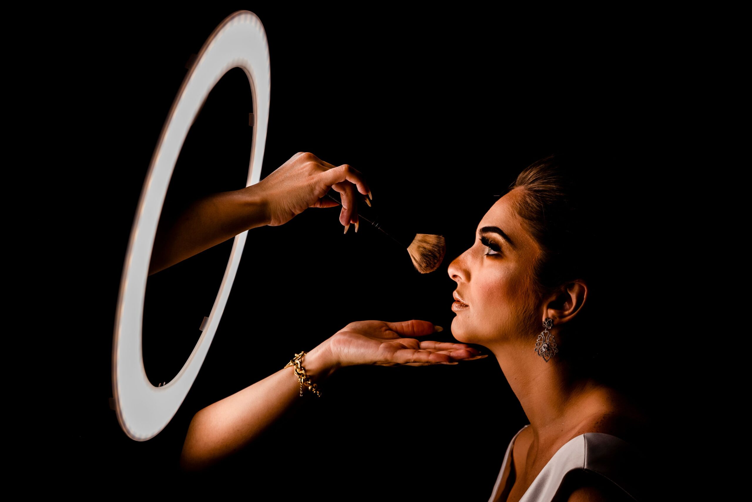 Elegant makeup application in a studio setting with professional lighting.